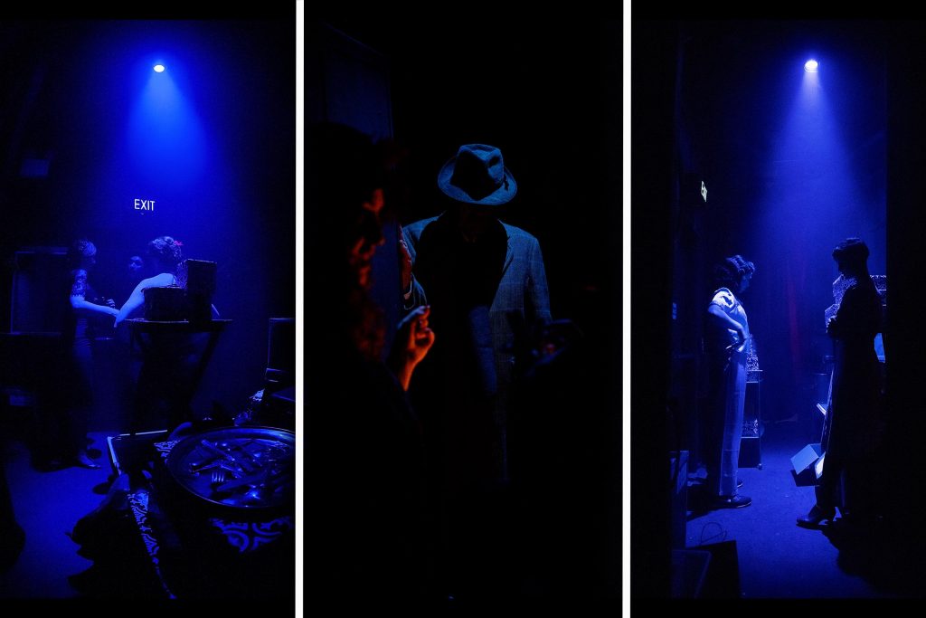 The cast wait backstage in the dim blue down lights